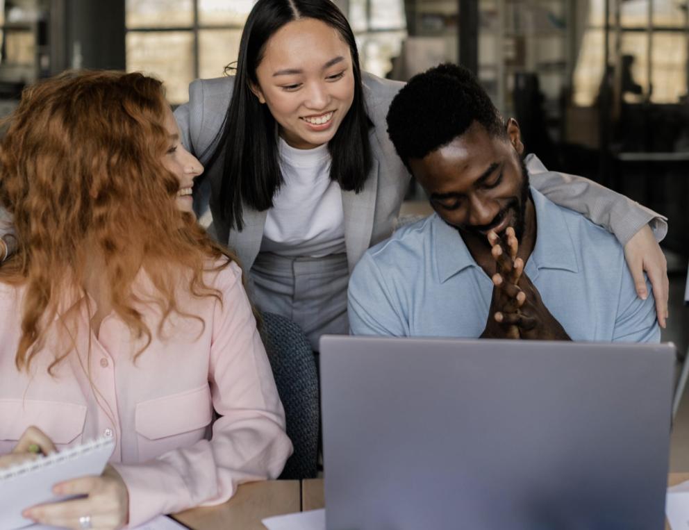 Three mentors working together at a computer.